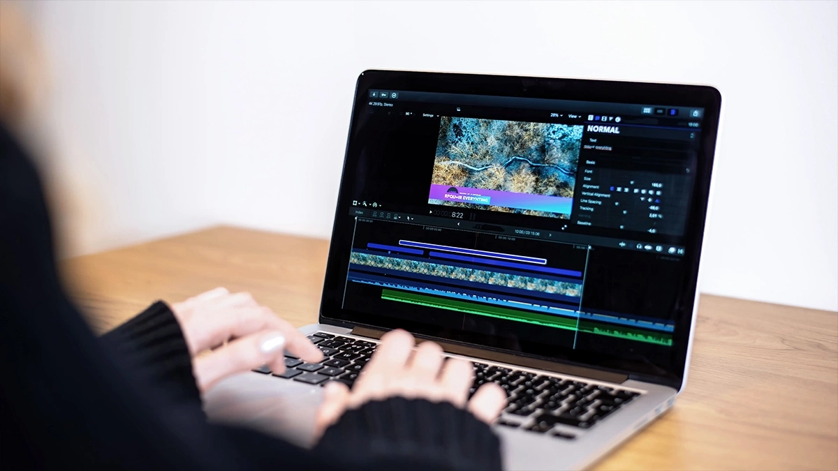 Video editing timeline on a laptop with a vertical clip and on-screen text captions being added
