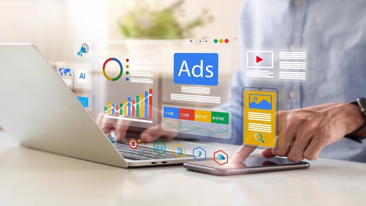 Person managing an ads dashboard with campaign charts and spend figures across a laptop and phone